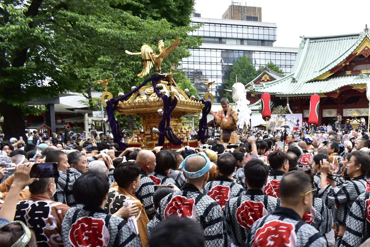 Kanda Matsuri sırasında Kanda Myojin'in ana salonunun önünde festival ceketli bir kalabalık tarafından taşınan yaldızlı bir taşınabilir tapınak